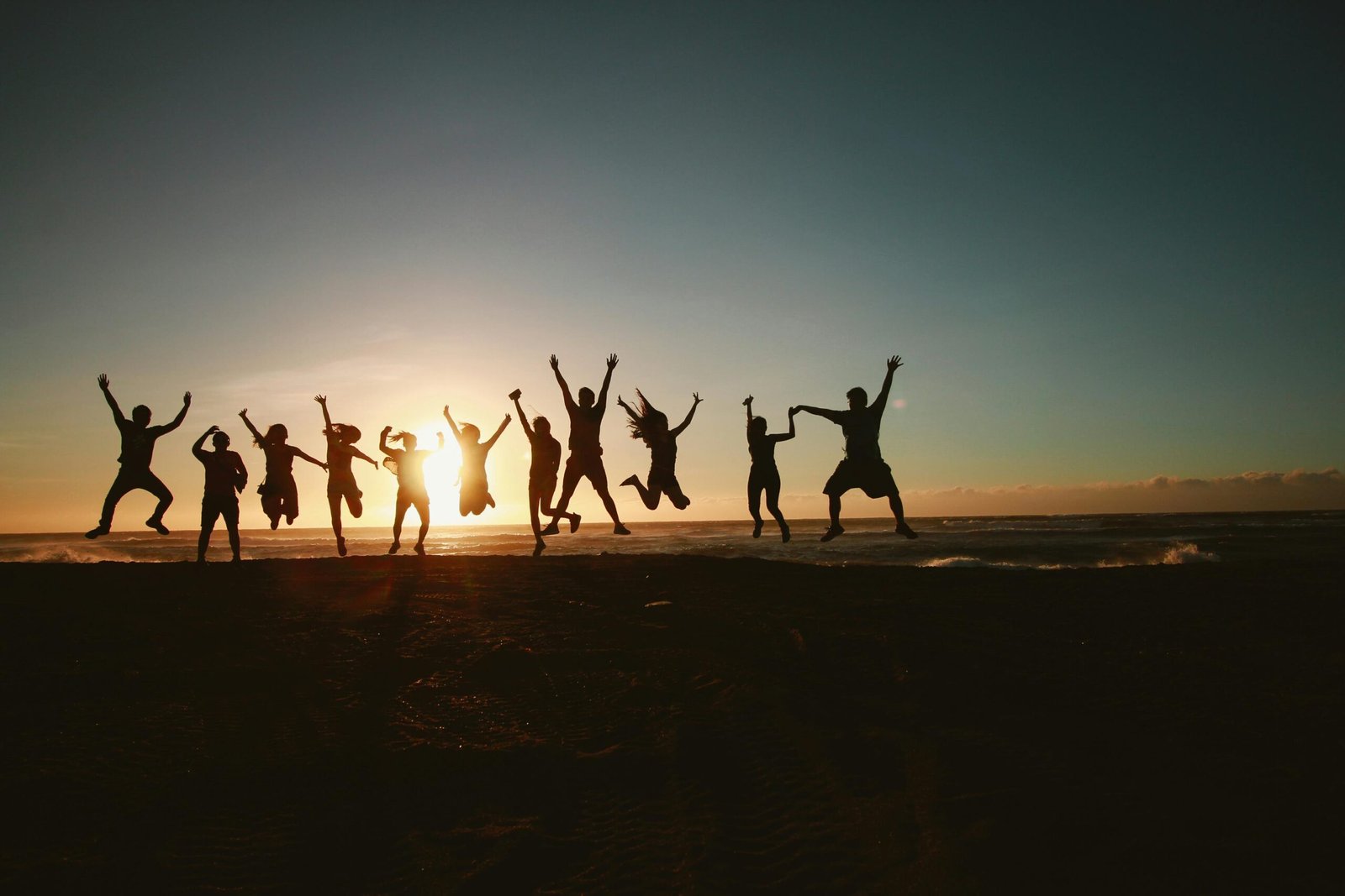 ERA About 1 Silhouettes of a joyful group jumping on a beach at sunset, symbolizing unity, freedom, and positive energy